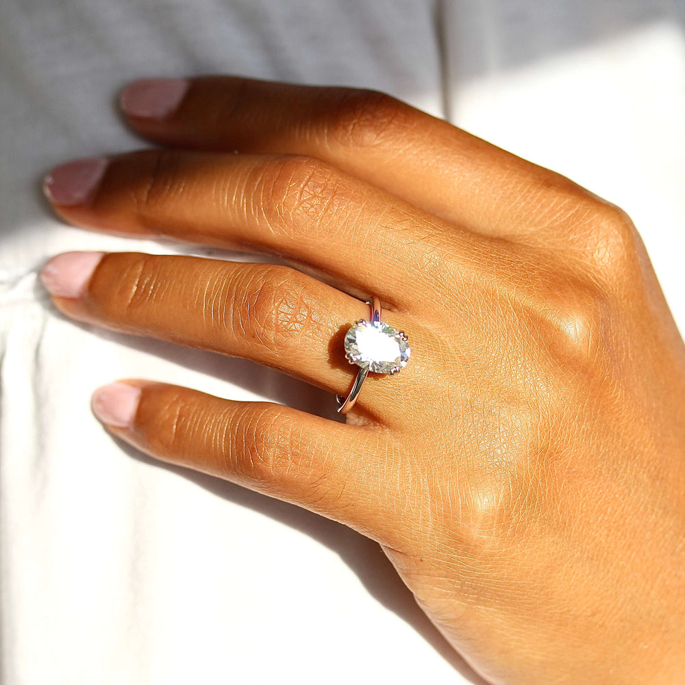 The Serena Ring (Oval) in white gold and Moissanite modeled on the hand