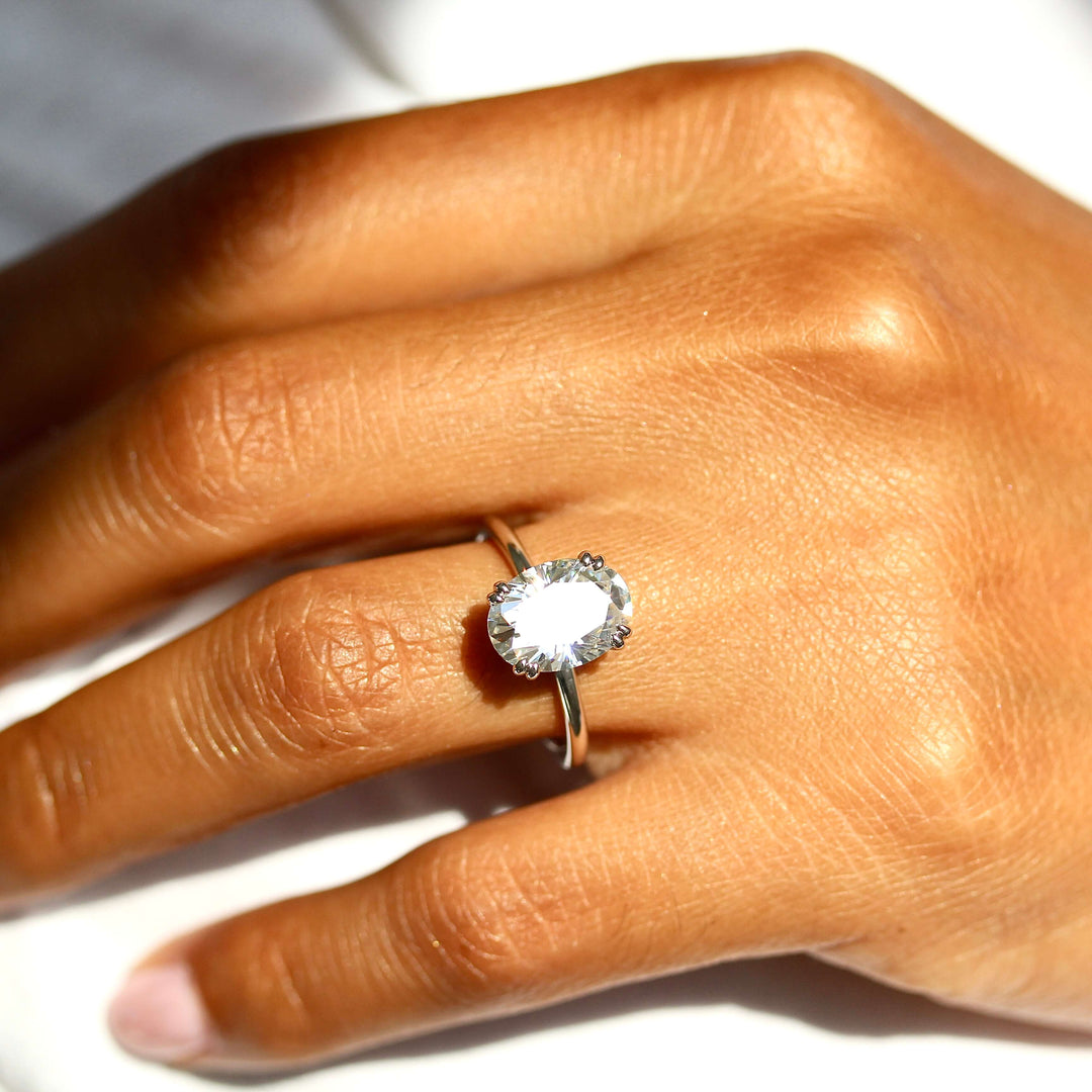 The Serena Ring (Oval) in white gold and Moissanite modeled on the hand