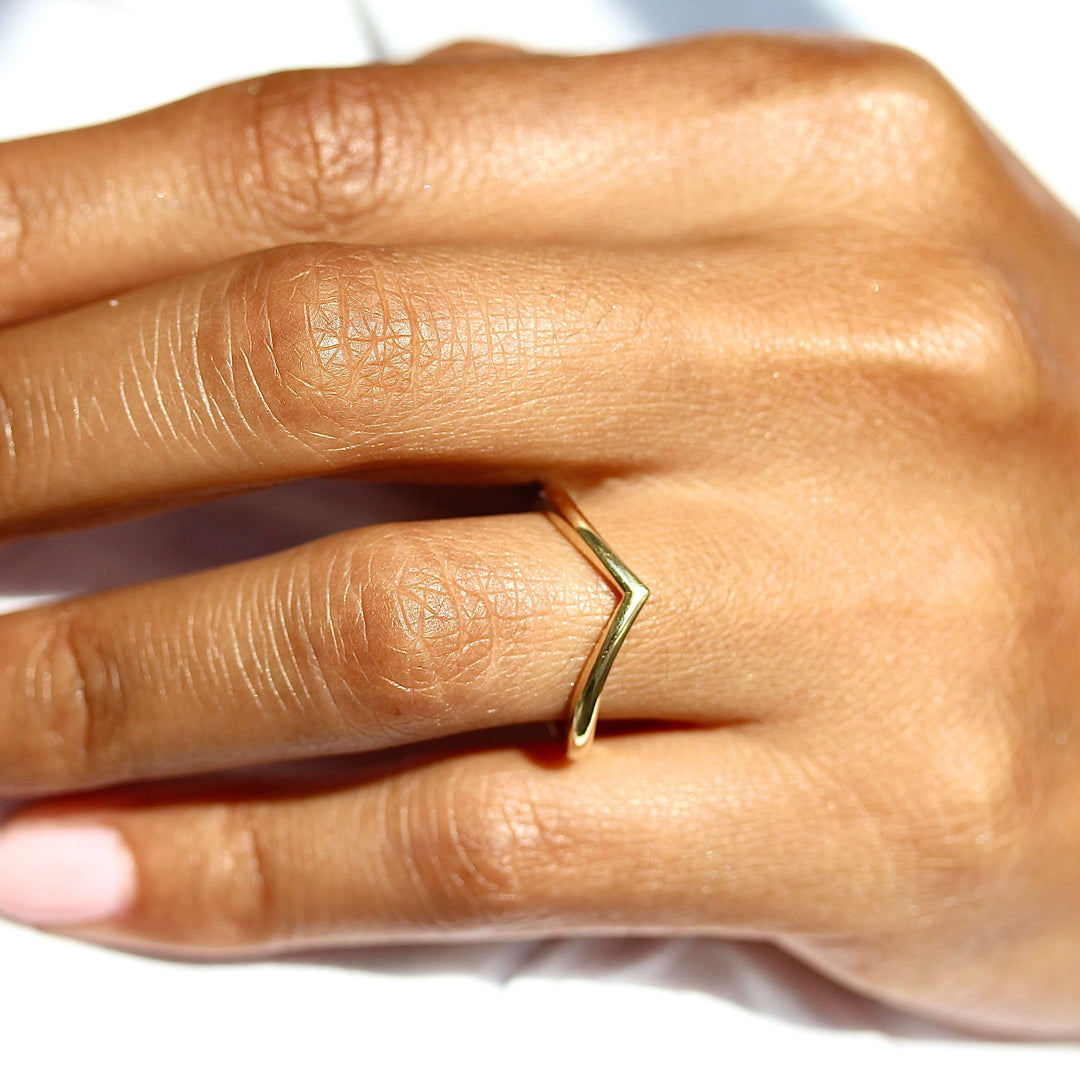 The V Wedding Band in yellow gold modeled on a hand