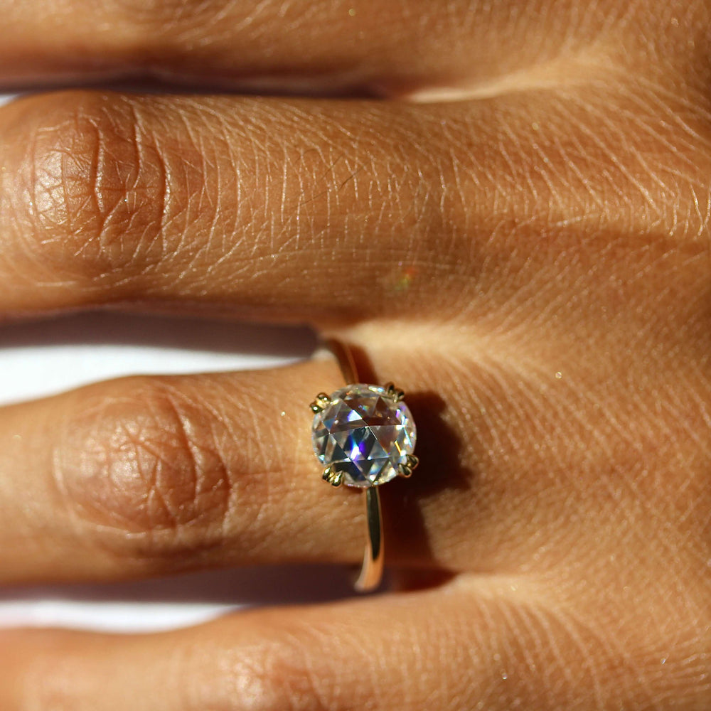 The Nora Ring (Round) in Yellow Gold and Moissanite modeled on a hand