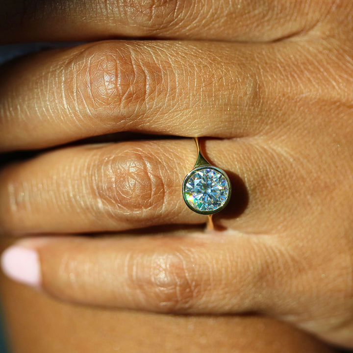 The Stevie Ring (Round) in Yellow Gold with 2ct Moissanite modeled on a hand