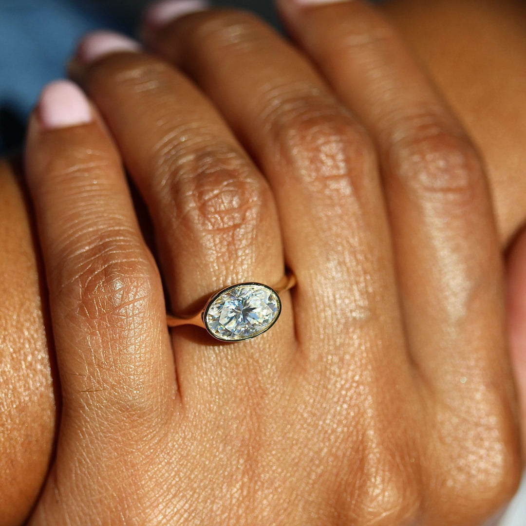 The Stevie Ring (East-West Oval) in Yellow Gold with 2ct Moissanite modeled on a hand