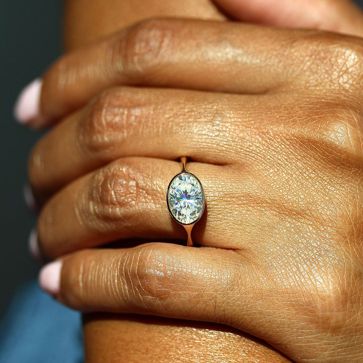 The Stevie Ring (East-West Oval) in Yellow Gold with 2ct Moissanite modeled on a hand