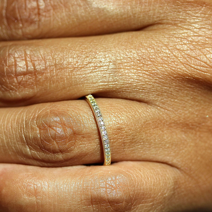 The Amber Wedding Band in Yellow Gold modeled on a hand