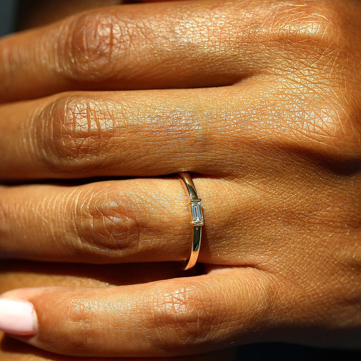 The Single Baguette Ring in Yellow Gold modeled on a hand