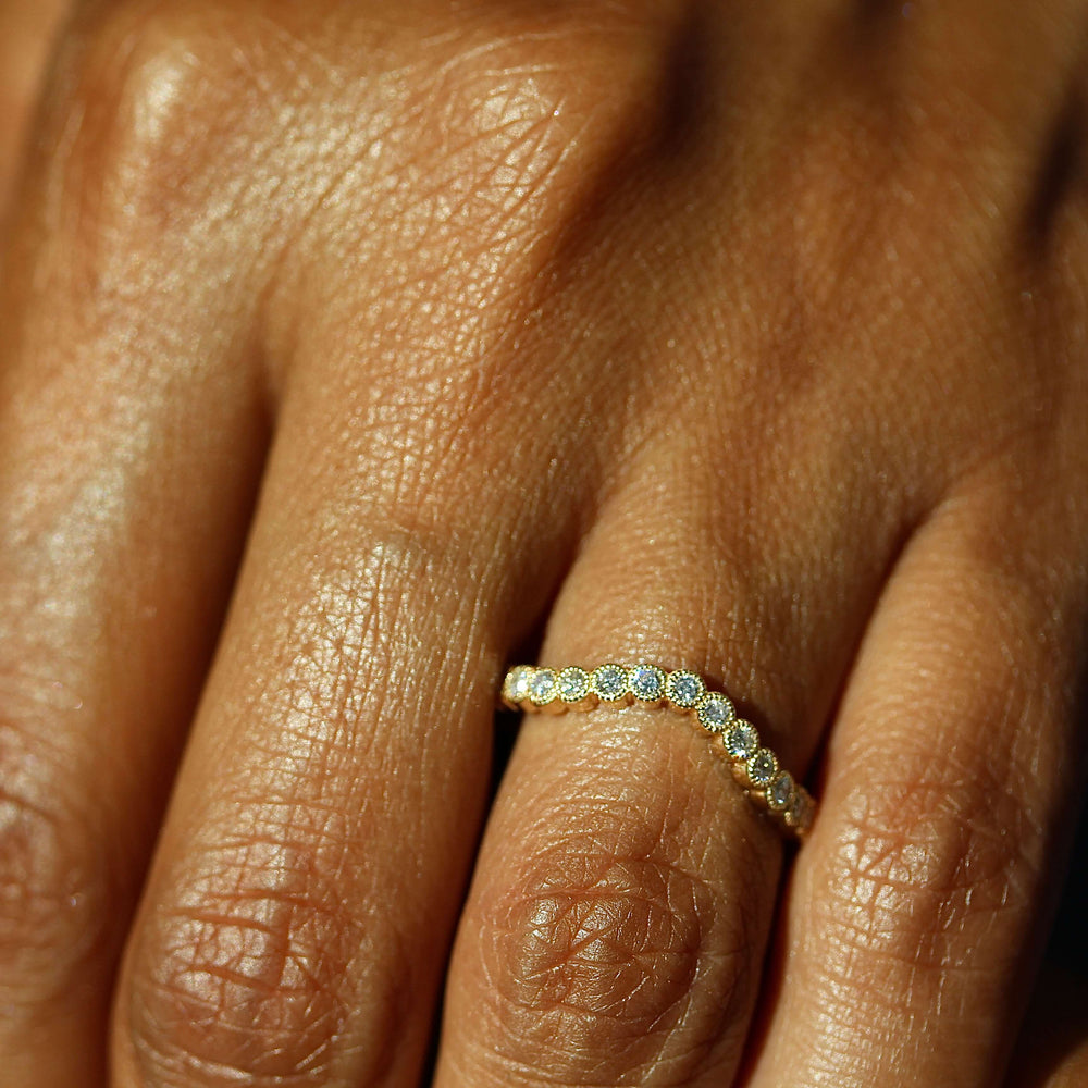 The Florence Contour Wedding Band in Yellow Gold modeled on a hand