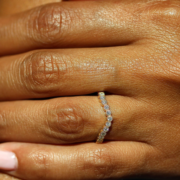 The Florence Contour Wedding Band in Yellow Gold modeled on a hand