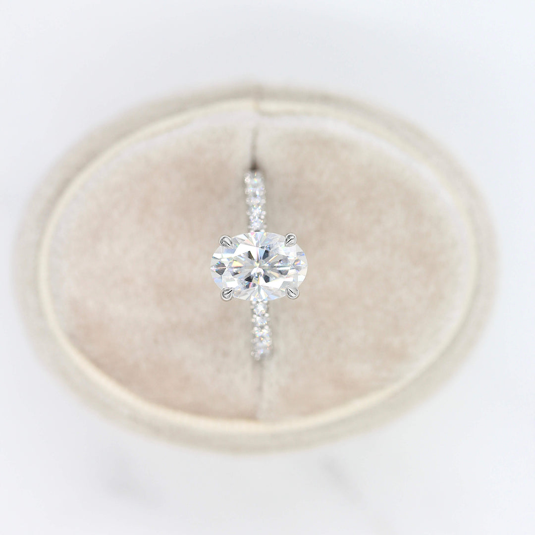 The Athena Hidden Halo Ring (Oval) in White Gold and Moissanite in a tan velvet ring box