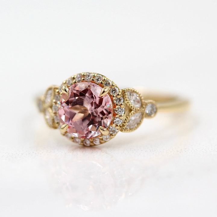 The Cate Ring (Round) in Yellow Gold and Peachy-Pink Created Sapphire against a white background