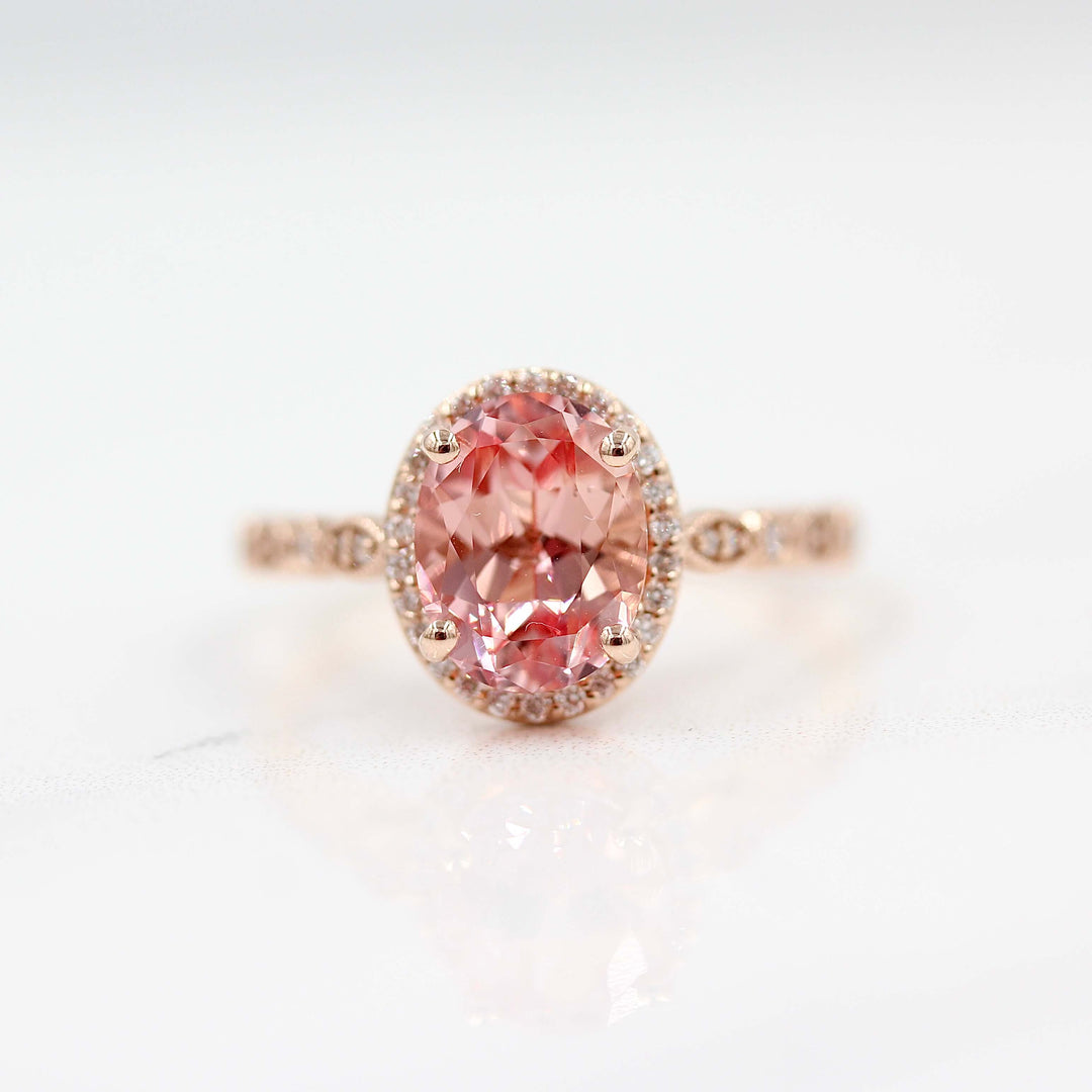 The Charlotte Ring with Peachy-Pink Created Sapphire in rose gold against a white background