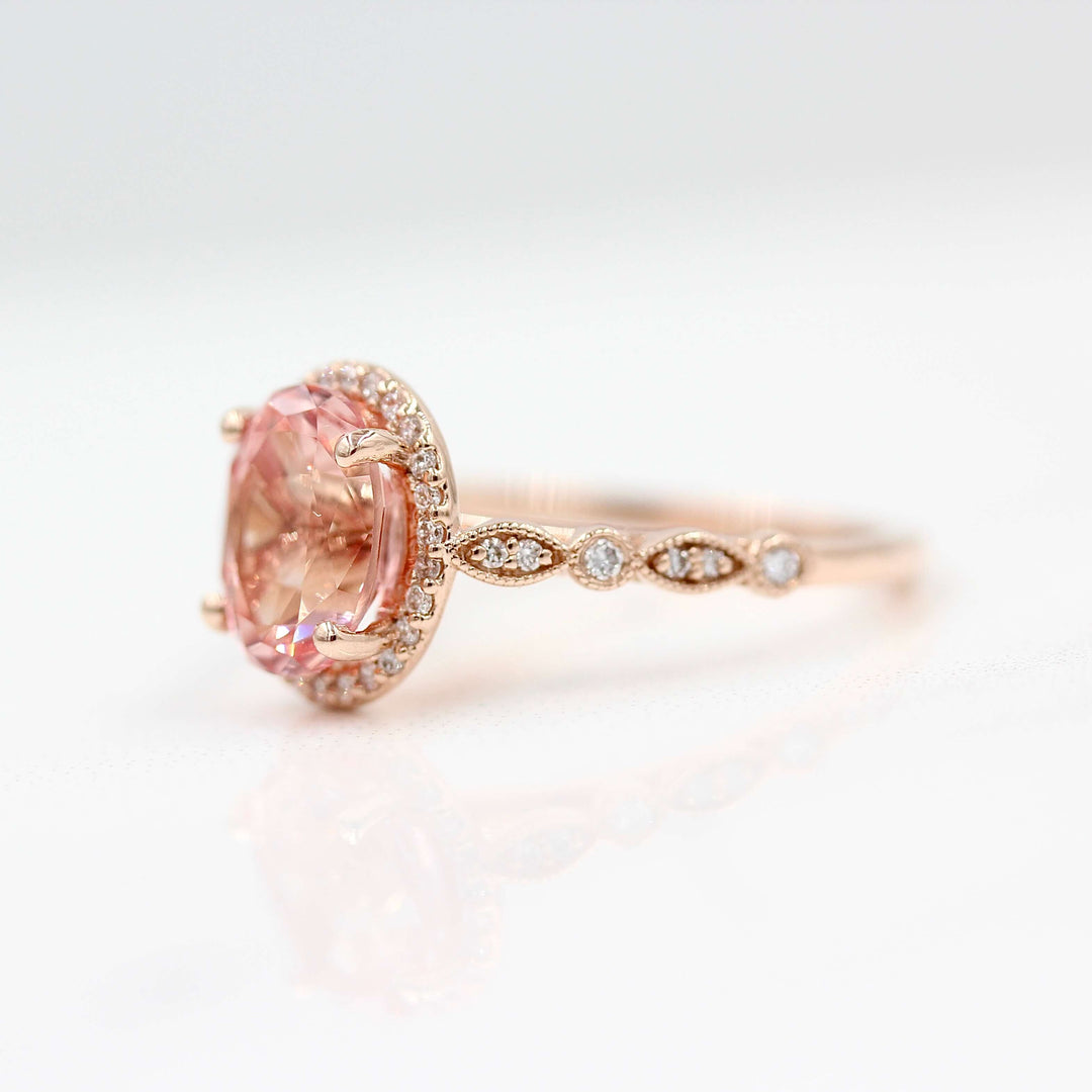 The Charlotte Ring with Peachy-Pink Created Sapphire in rose gold against a white background