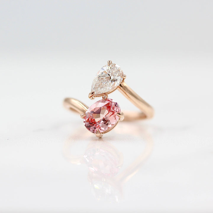 Toi et Moi Diamond and Peachy-Pink Sapphire Bypass Ring in Rose Gold against a white background
