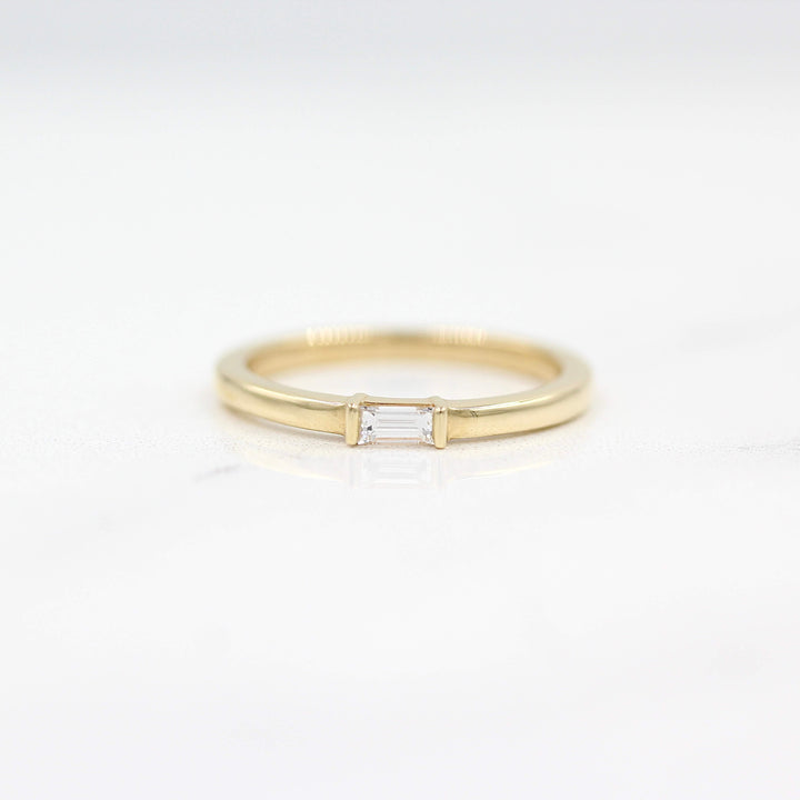 The Single Baguette Ring in Yellow Gold against a white background