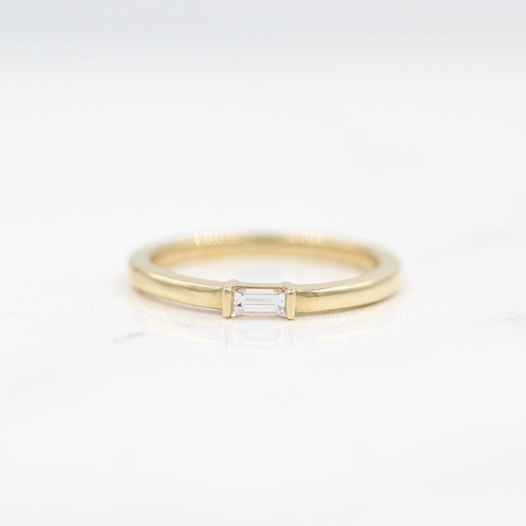 The Single Baguette Ring in Yellow Gold against a white background