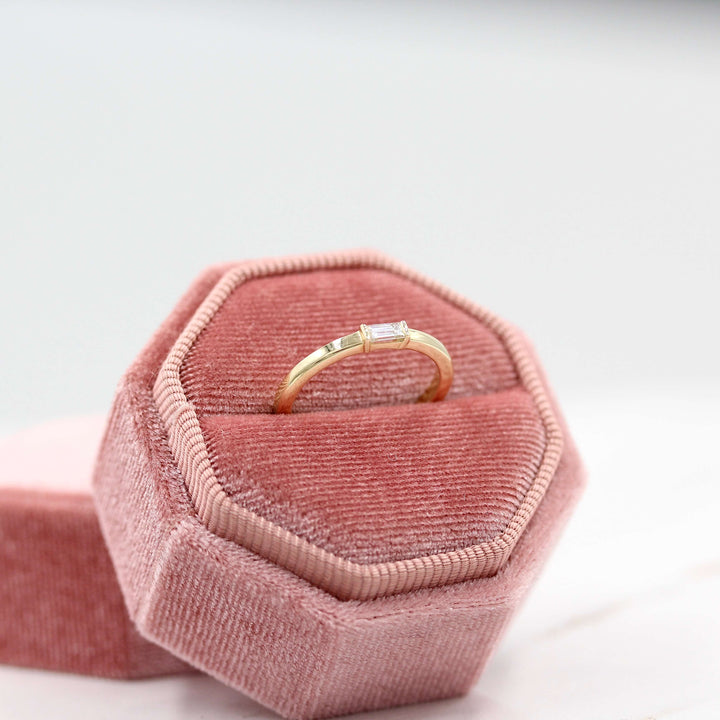 The Single Baguette Ring in Yellow Gold in a pink velvet ring box
