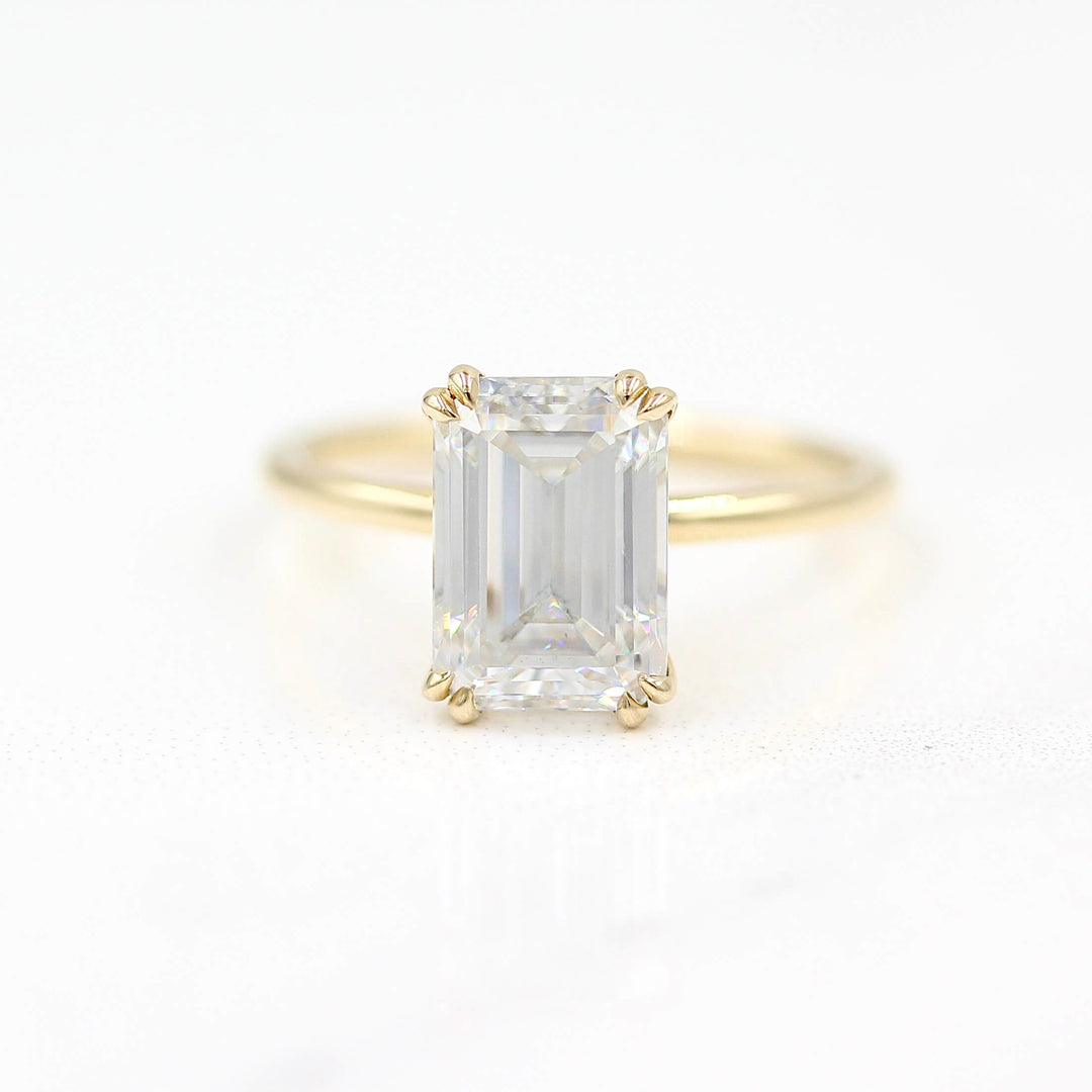 The Serena Ring (Emerald) in Yellow Gold and Moissanite against a white background