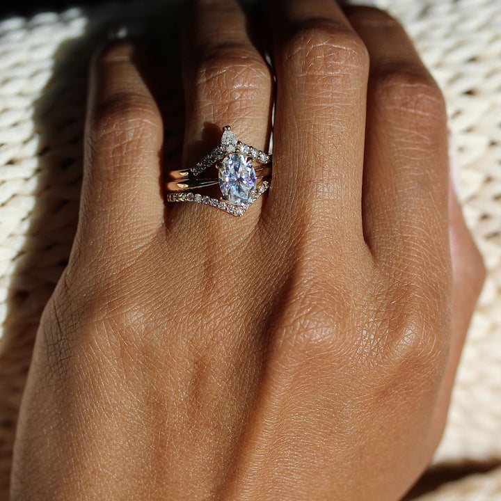 The Margot Ring (Oval) in Yellow Gold stacked with the Diamond V-Band and the Pinnacle Wedding Band in yellow gold modeled on a hand