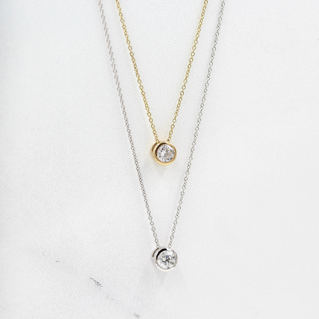 1/2ct Diamond Bezel Necklace in Yellow Gold and the 1/2ct Diamond Bezel Necklace in White Gold against white background