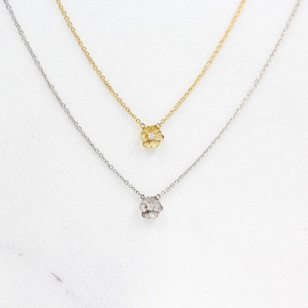 two poppy necklaces, one in white gold and one in yellow gold