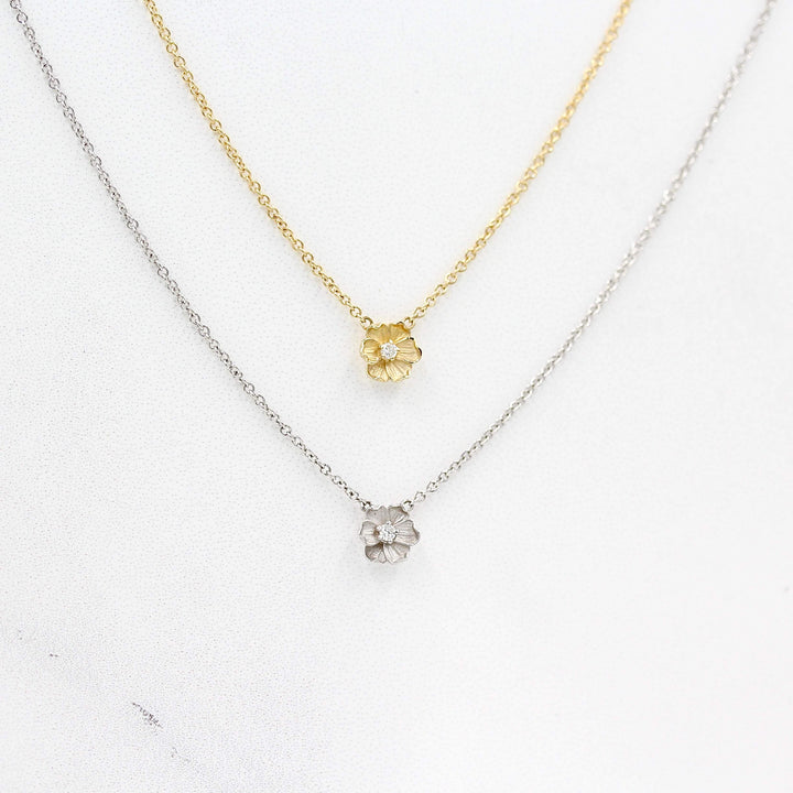 The Poppy Necklace in White Gold and the Poppy Necklace in Yellow Gold against a white background