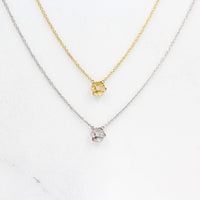 The Poppy Necklace in White Gold and the Poppy Necklace in Yellow Gold against a white background