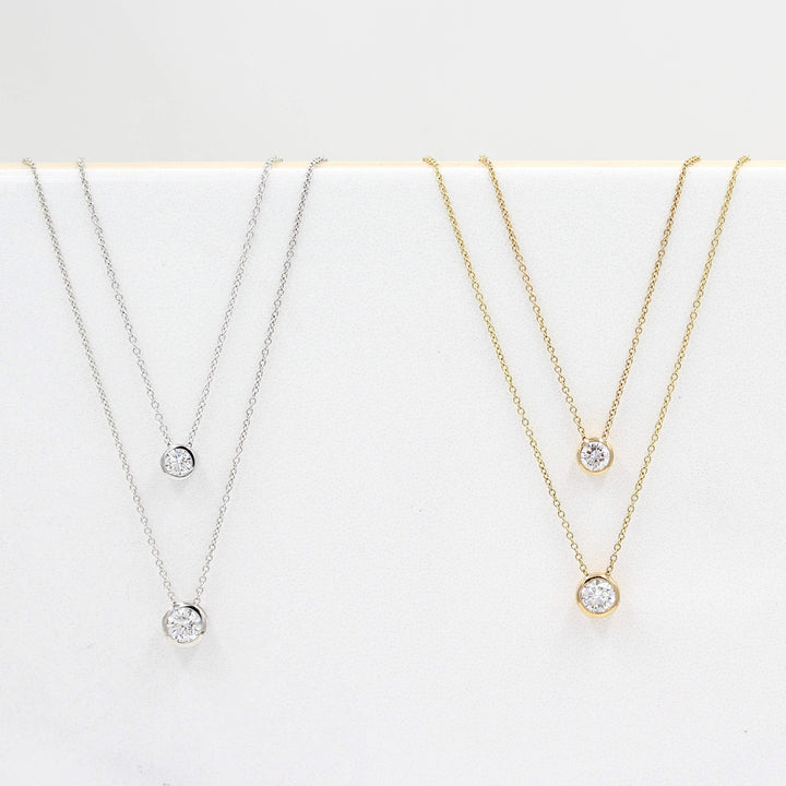 1/2ct Diamond Bezel Necklace in Yellow Gold, 1/4ct Diamond Bezel Necklace in Yellow Gold, 1/2ct Diamond Bezel Necklace in White Gold, and the 1/4ct Diamond Bezel Necklace in White Gold against a white background