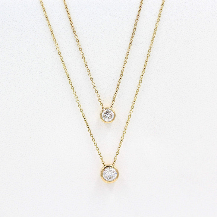 1/2ct Diamond Bezel Necklace in Yellow Gold and the 1/4ct Diamond Bezel Necklace in Yellow Gold against a white background