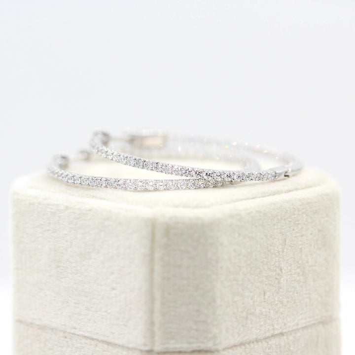 Inside and Outside Hoops in white gold resting atop a tan velvet ring box