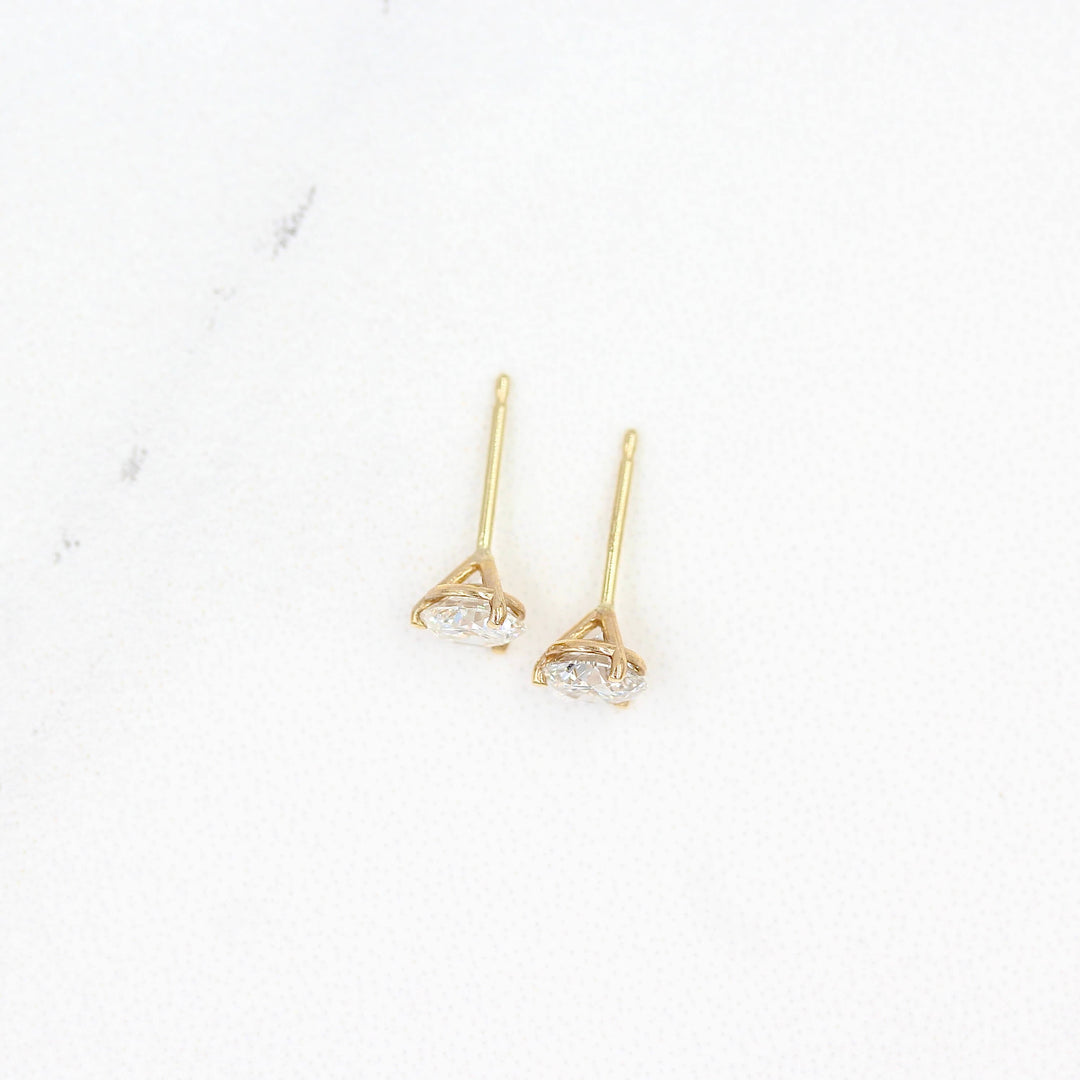 Martini Mounting Diamond Studs in yellow gold against a white background