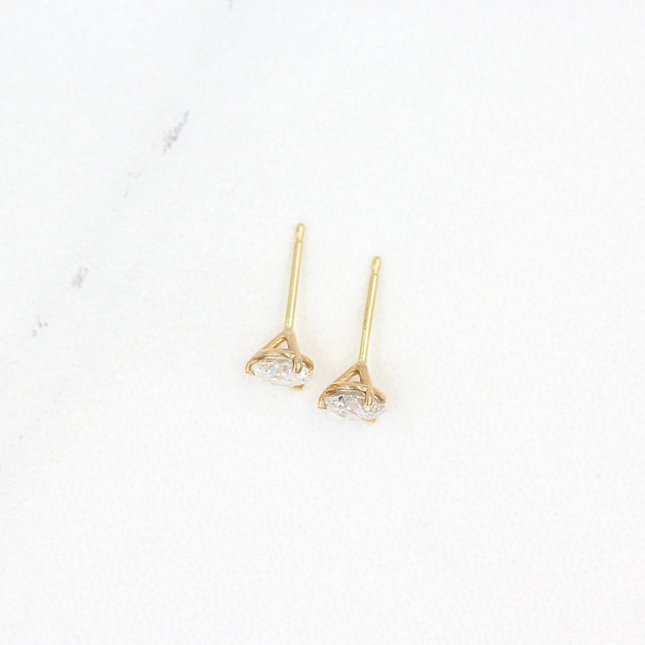 Martini Mounting Diamond Studs in yellow gold against a white background