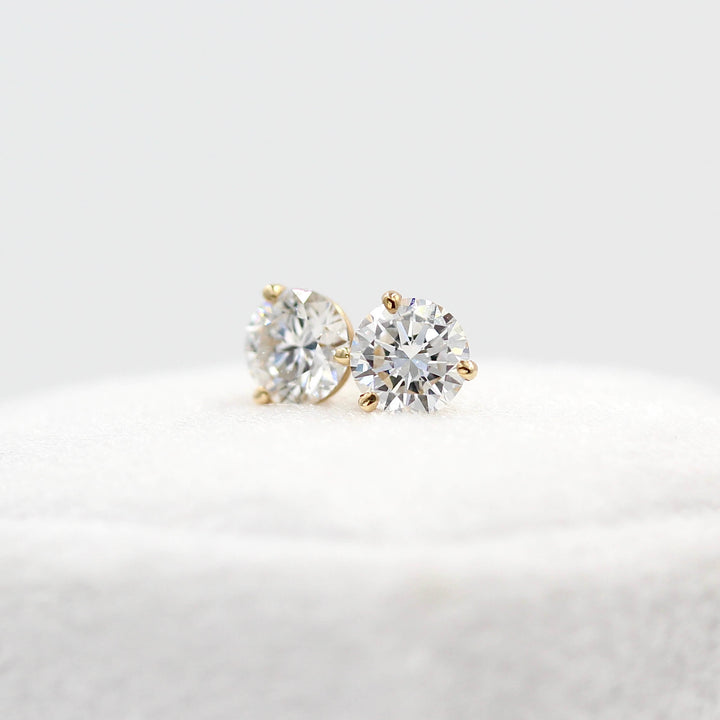 Martini Mounting Diamond Studs in yellow gold resting atop a white velvet ring box