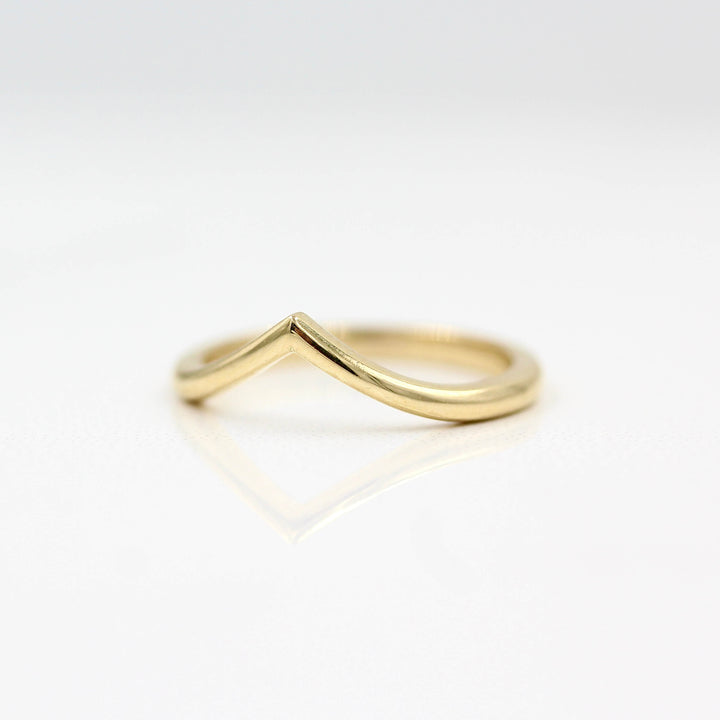 The V Wedding Band in yellow gold against a white background