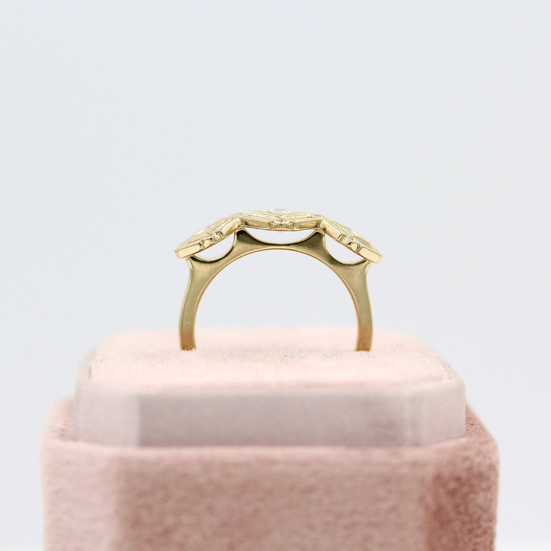 A profile shot of the Darby ring in yellow gold in a pink velvet ring box