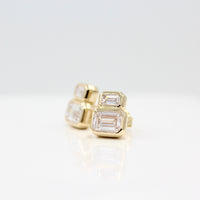 Emerald-Cut Diamond Two-Stone Earrings in yellow gold with 3ct total weight against a white background