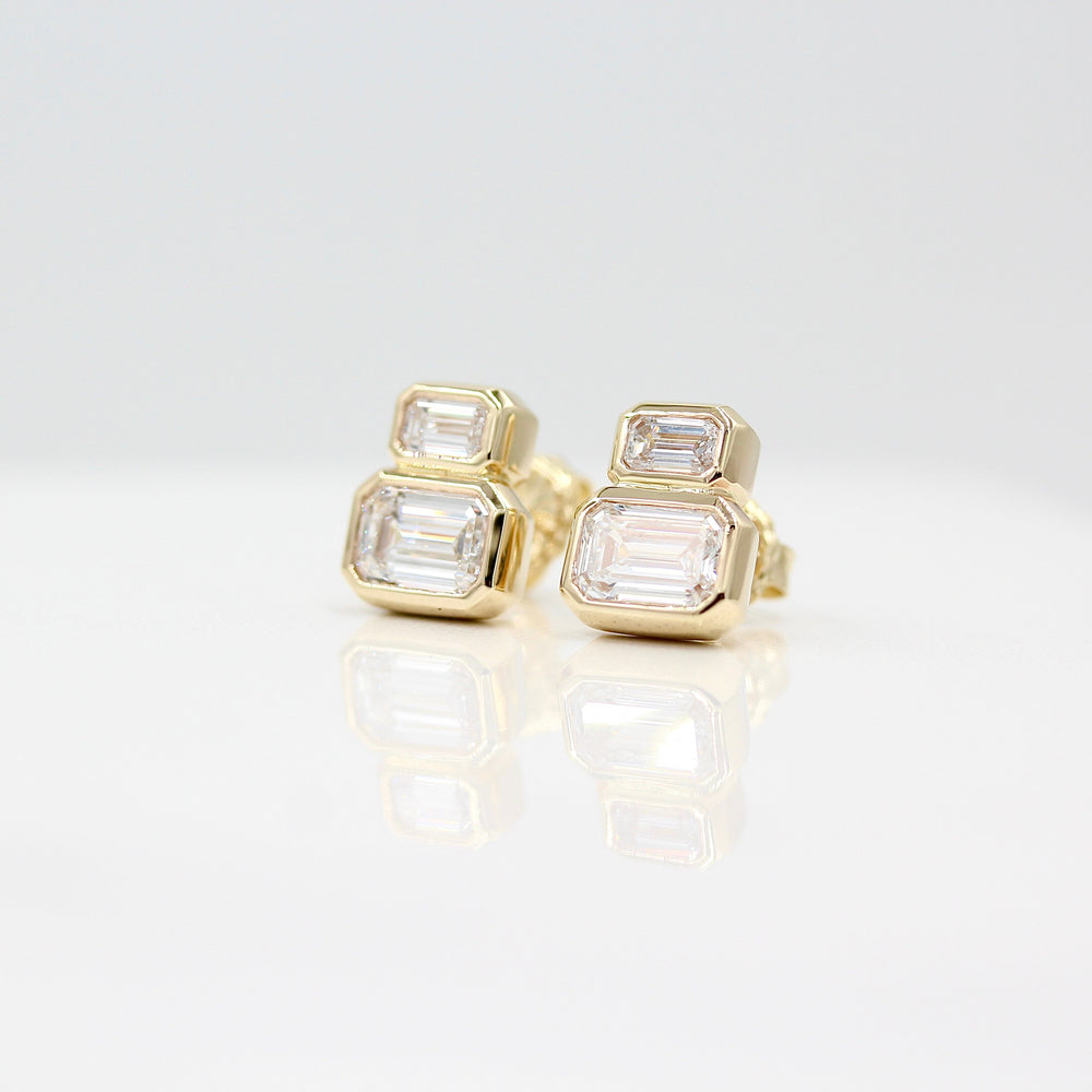 Emerald-Cut Diamond Two-Stone Earrings in yellow gold with 3ct total weight against a white background