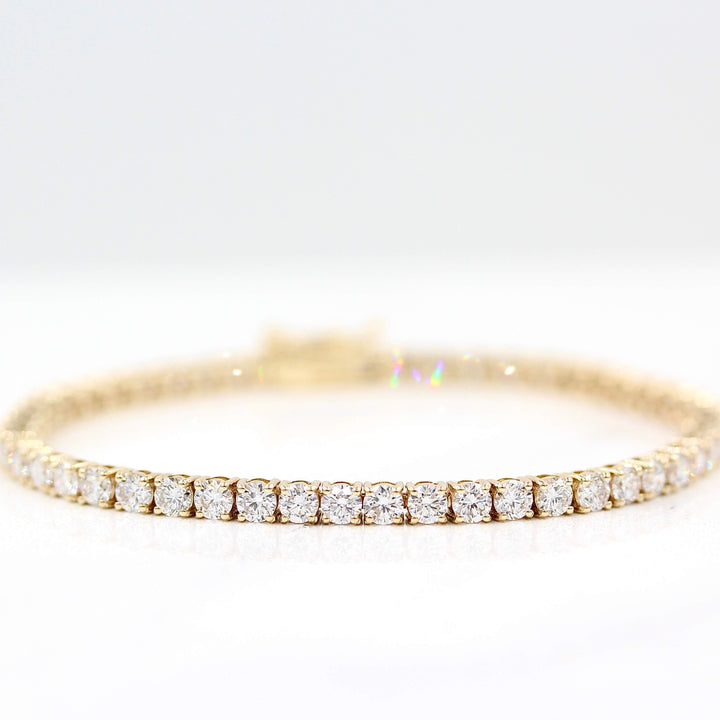 The Classic Lab Grown Diamond Tennis Bracelet in Yellow Gold and 7.04ct against a white backbround