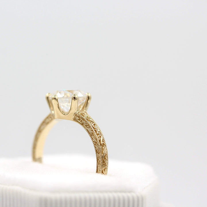 The Kathleen ring in yellow gold's profile shot in a white velvet ring box