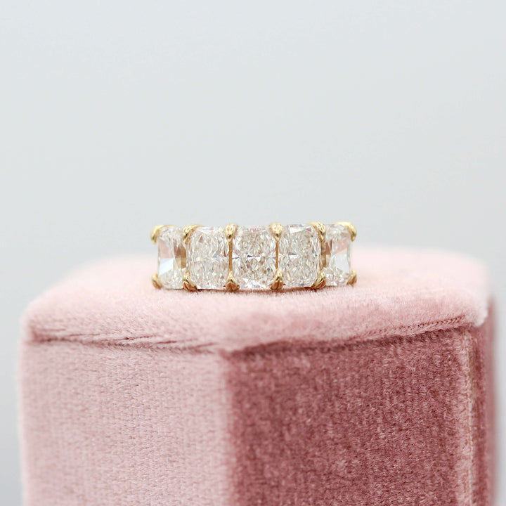 The Keeley Wedding Band in Yellow Gold atop of a pink velvet ring box