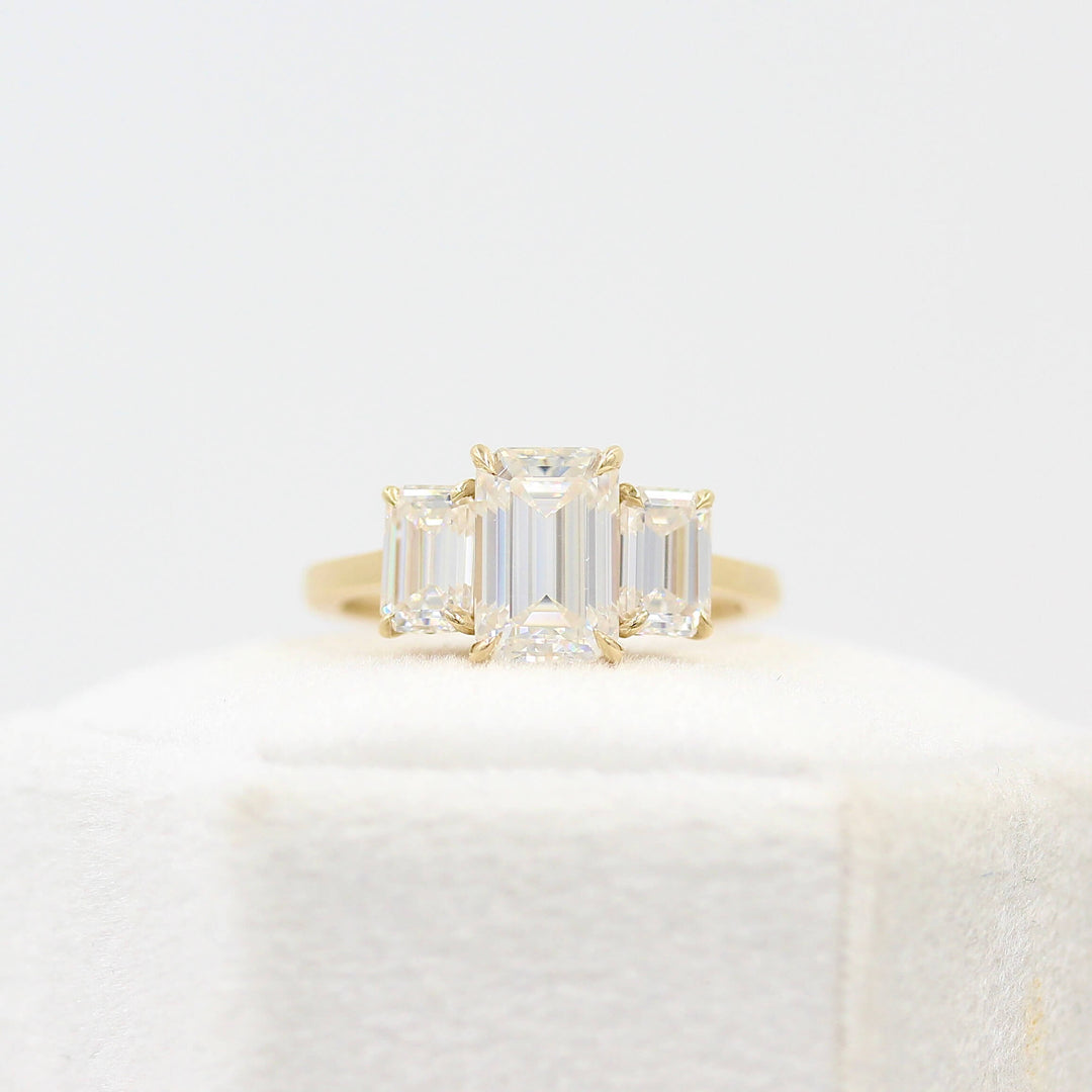 The Kendall Hidden Halo Ring in Yellow Gold with Moissanite atop a white velvet ring box