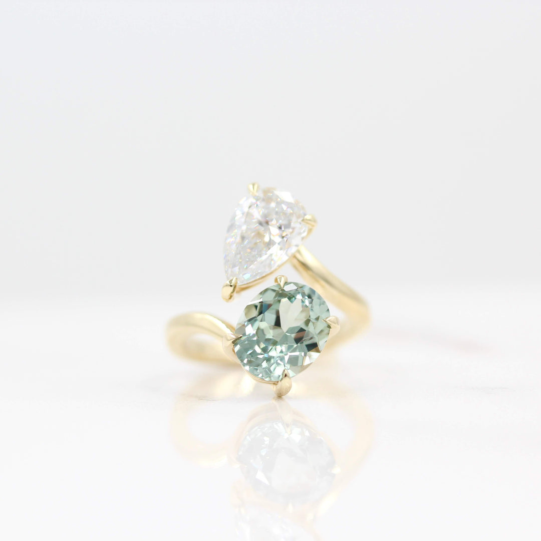 La Grande Toi Et Moi Ring Diamond and Sage Green Sapphire Bypass Ring against a white background