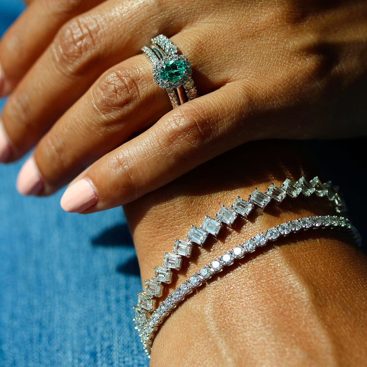 The Ava Ring with Minty Green Chrysoberyl in White Gold stacked with the Lauryn Wedding Band in white gold and the Open Lexington Wedding Band in white gold modeled on a hand with the Emerald Lab Grown Tennis Bracelet in white gold and the Classic 6.02ct Lab Grown Diamond Tennis Bracelet in white gold