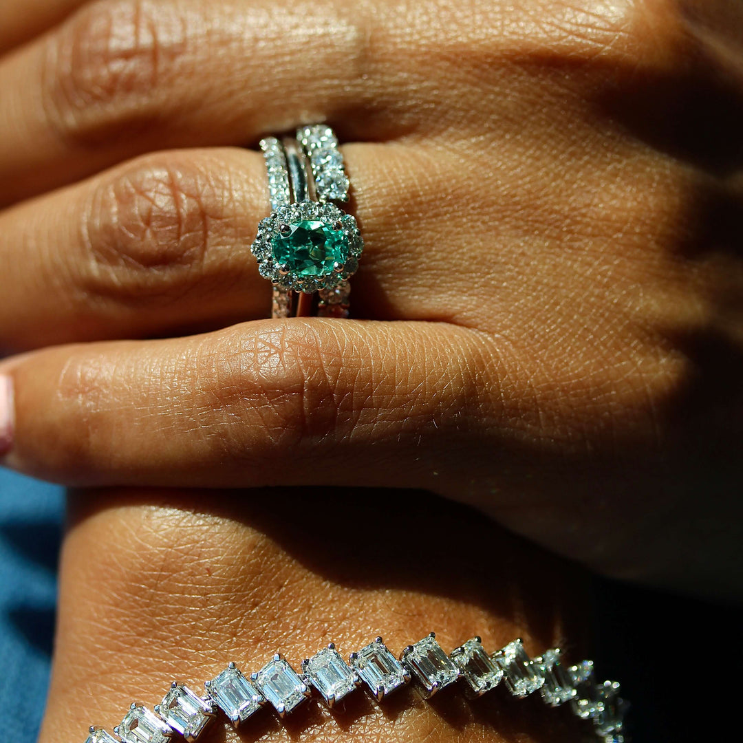 The Ava Ring with Minty Green Chrysoberyl in White Gold stacked with the Lauryn Wedding Band in white gold and the Open Lexington Wedding Band in white gold modeled on a hand with the Emerald Lab Grown Tennis Bracelet in white gold