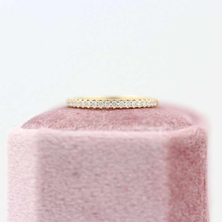 The Lauryn Wedding Band in Yellow Gold atop of a pink velvet ring box