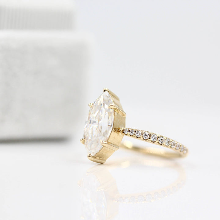 Maisie ring (marquise) in yellow gold in front of a white velvet ring box