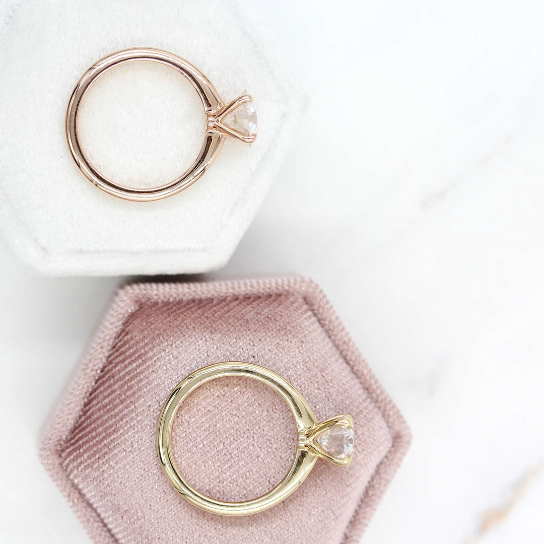 The Margot oval and round rings side by side on velvet ring boxes