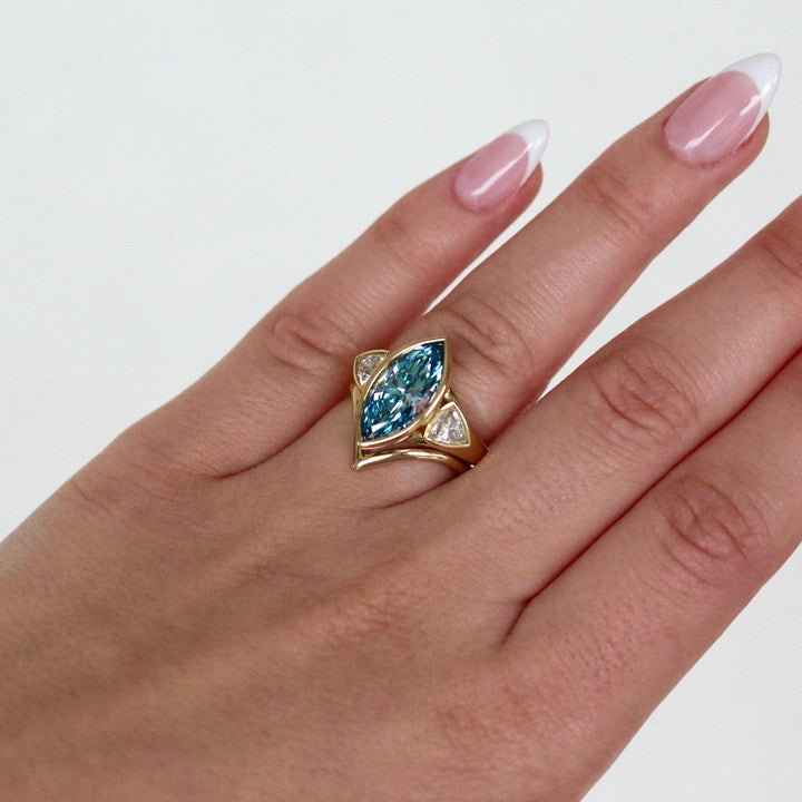 The Deep V Wedding Band in Yellow Gold stacked with the Morgan Ring in Yellow Gold with a Blue 3.5ct Marquise Lab-Grown Diamond modeled