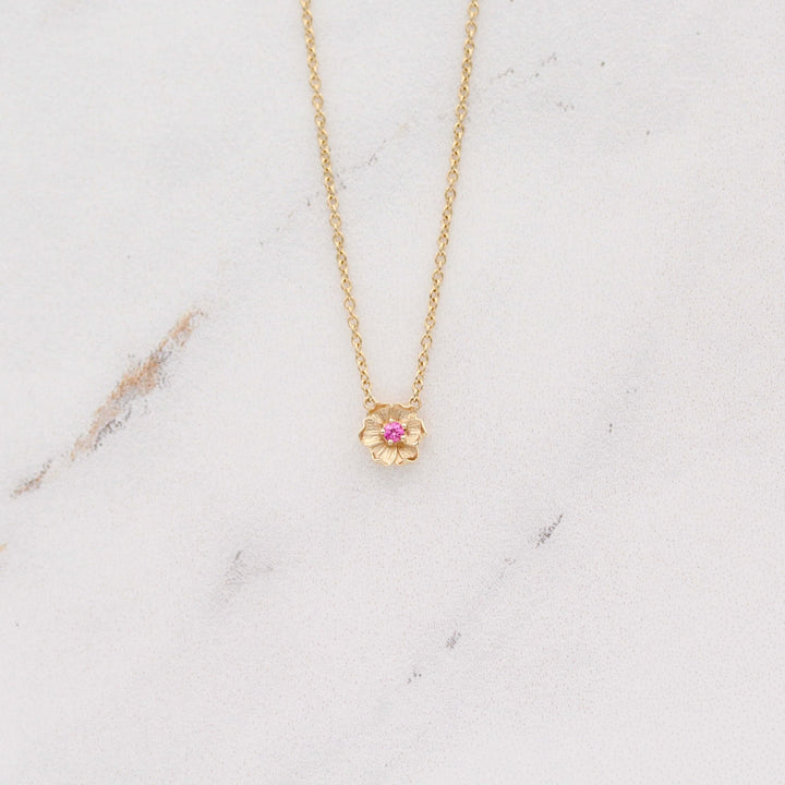 The January Birthstone Poppy Necklace with Padparadscha Sapphire in Yellow Gold against a white background