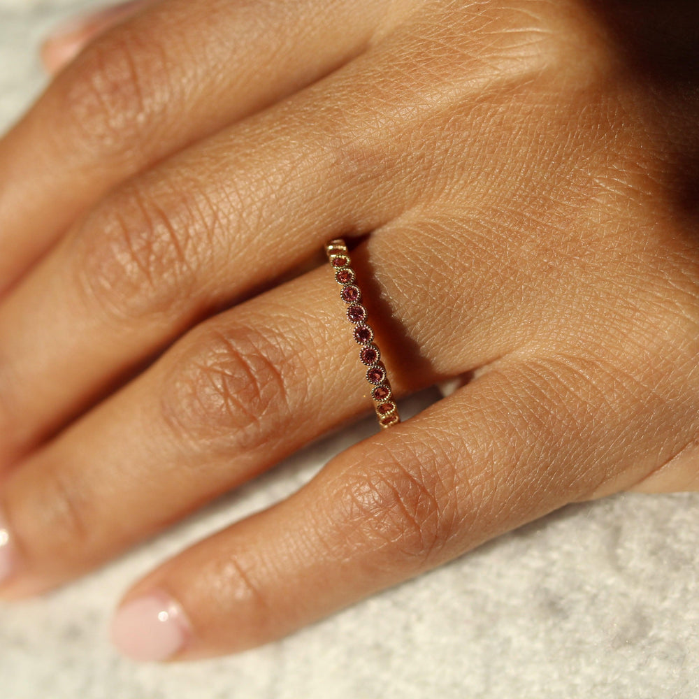The January Florence Birthstone Wedding Band with Padparadscha Sapphire in Yellow Gold modeled