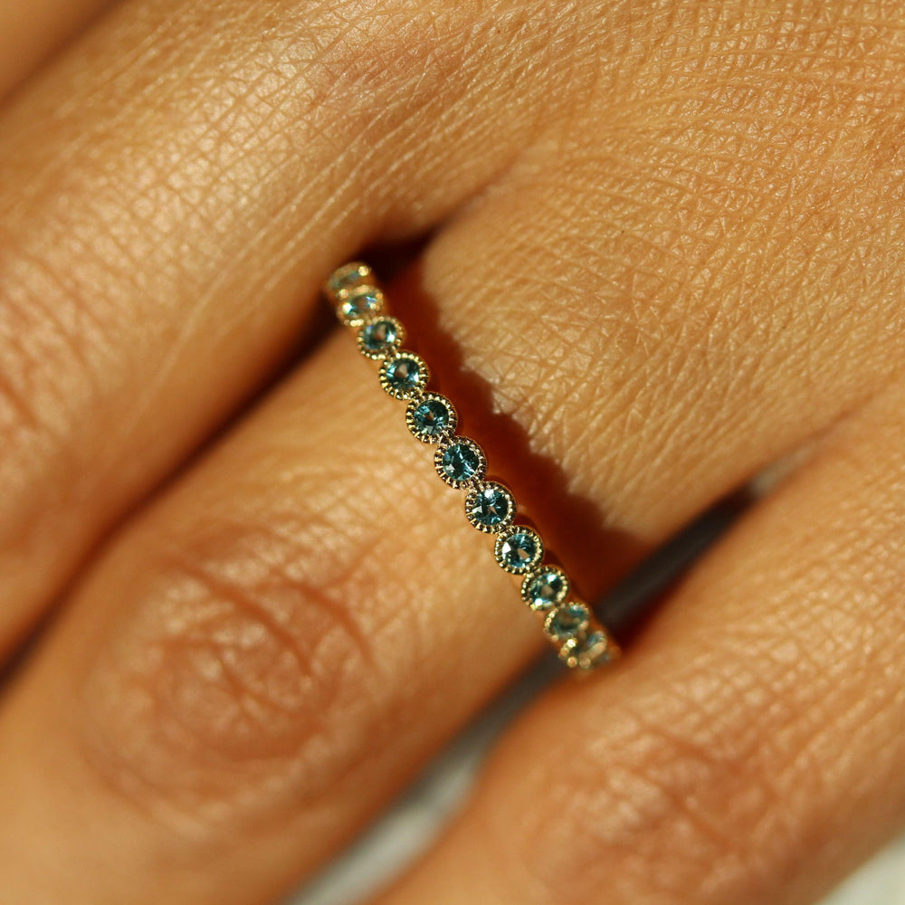 The December Florence Birthstone Wedding Band with Paraiba Spinel in Yellow Gold modeled