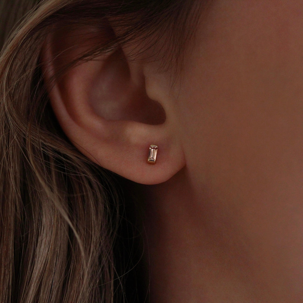 The October Baguette Birthstone Earrings with Peachy-Pink Sapphire in Yellow Gold modeled